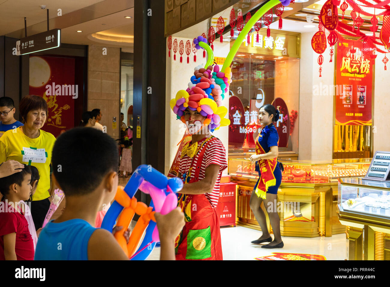 Balloon Fight zwischen Jungen und Clown in der Shopping Mall in China Stockfoto