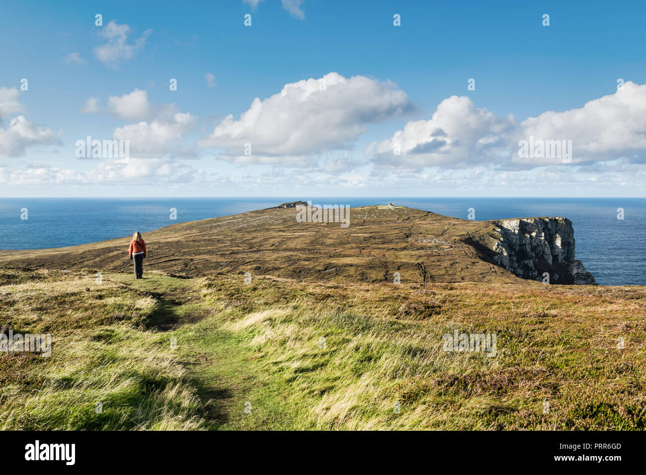 Dies ist eine Frau in der Nähe der Klippen von Horn Head Irland mit Blick auf den Ozean Horizont. Stockfoto