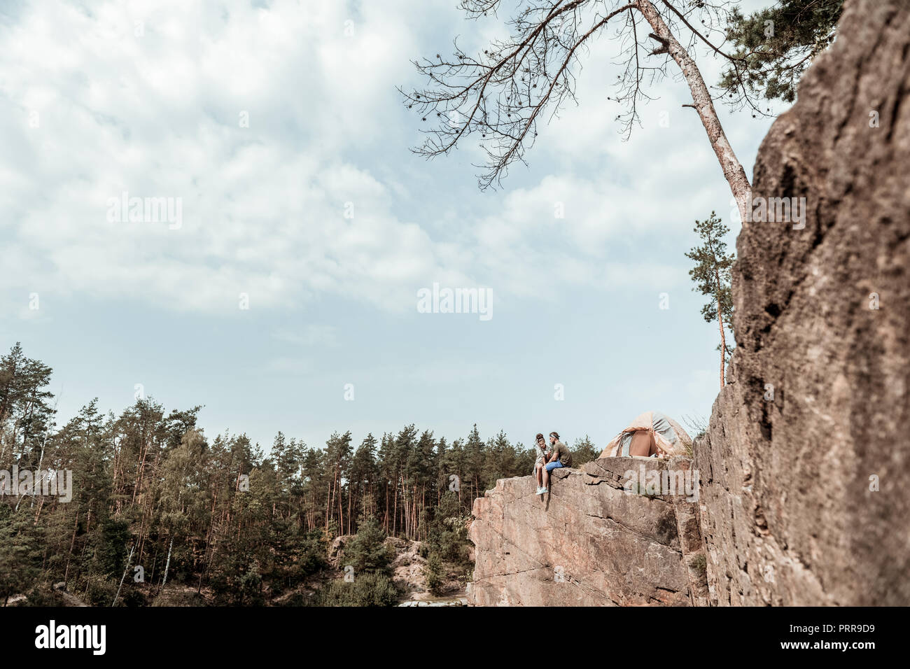 Low Angle lieben Backpackers Sitzung am Rande der Felsen in der Nähe von wunderschönen See Stockfoto