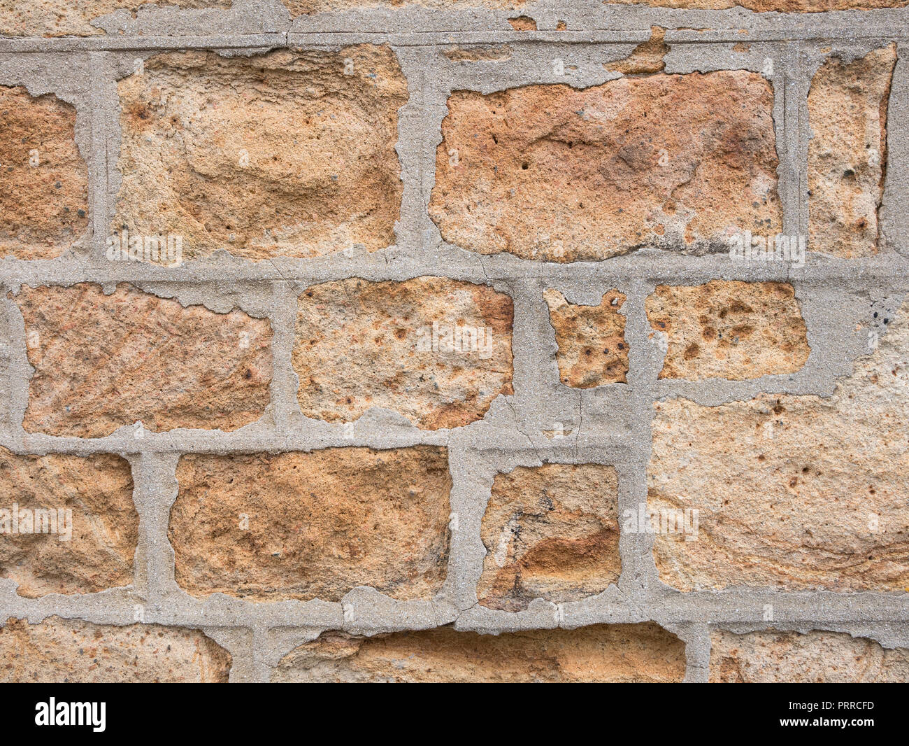 Alte Steinmauer. Alternde Sandsteinwand, die Anzeichen von Zerbröckeln zeigt. Stockfoto