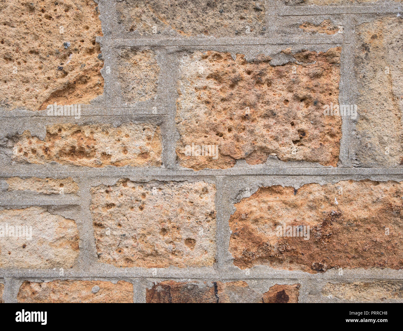 Alte Steinmauer. Alternde Sandsteinwand, die Anzeichen von Zerbröckeln zeigt. Stockfoto