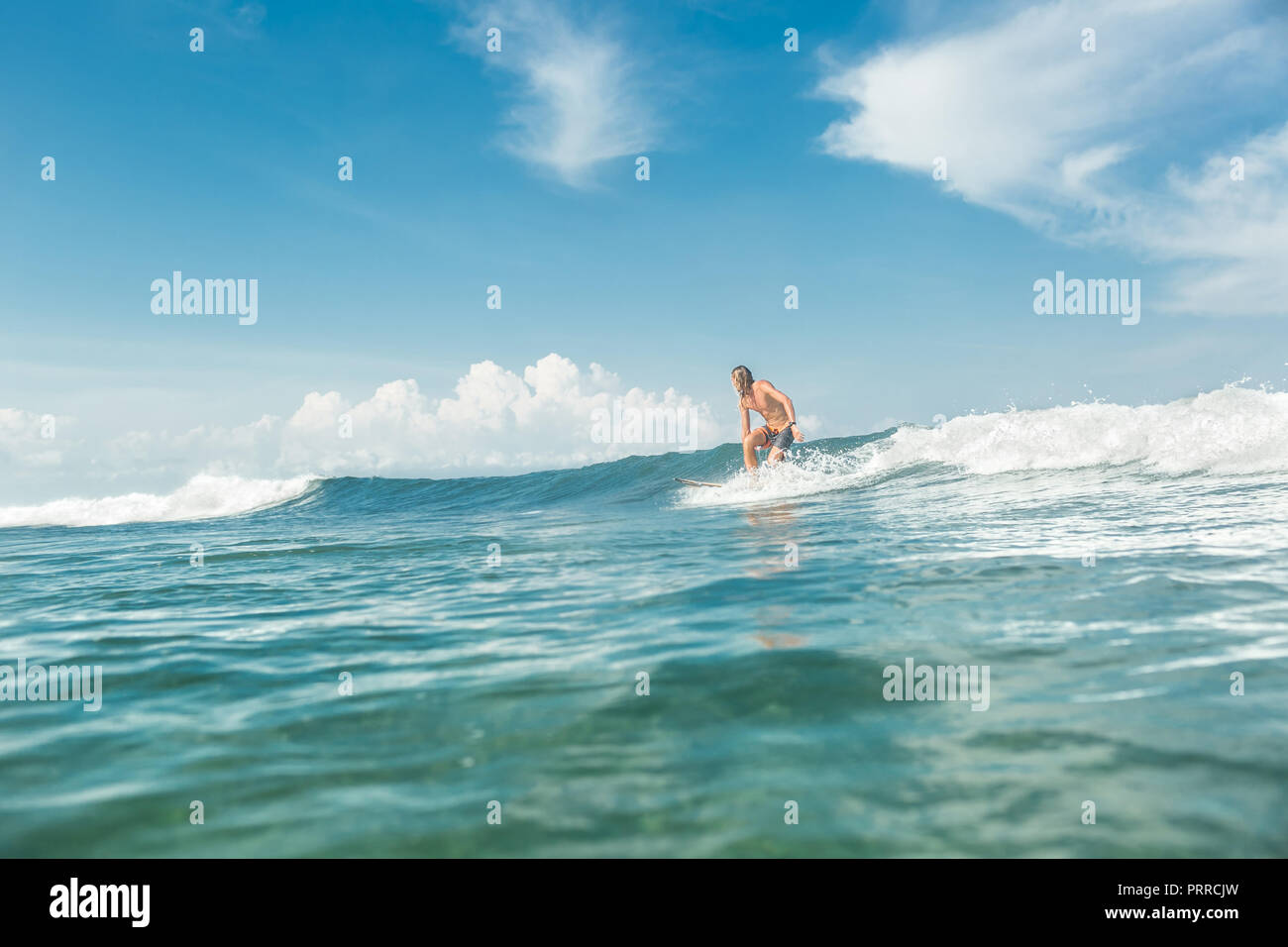 Fernsicht auf männliche Sportler Surfen im Meer am Sandstrand von Nusa Dua, Bali, Indonesien Stockfoto