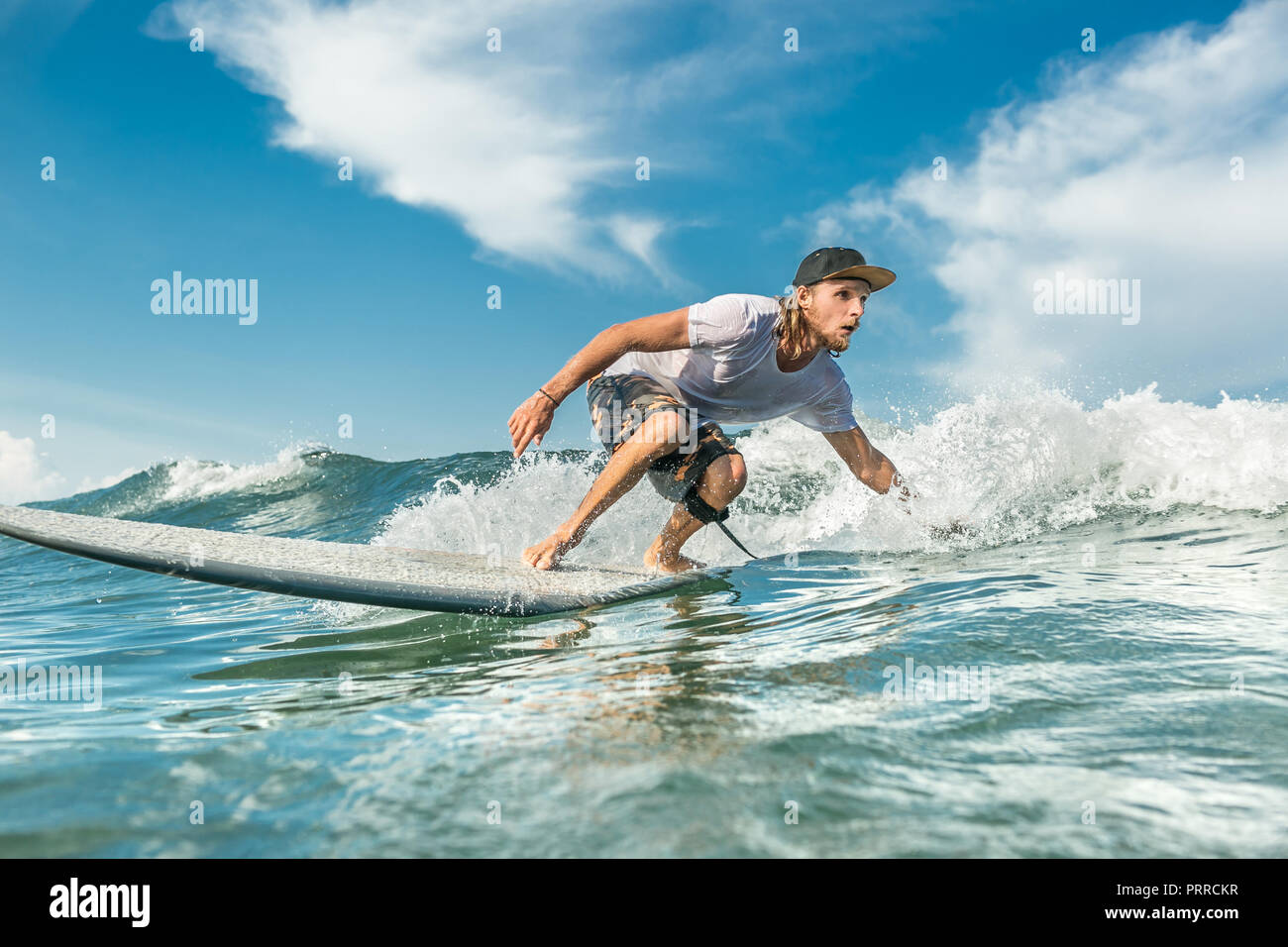 Geballte männliche Surfer reiten Wellen im Ozean am Sandstrand von Nusa Dua, Bali, Indonesien Stockfoto