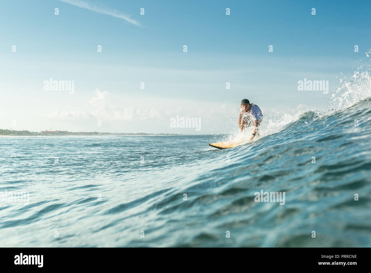 Selektiver Fokus der männlichen surfer Reiten an Bord im Ozean am Sandstrand von Nusa Dua, Bali, Indonesien Stockfoto