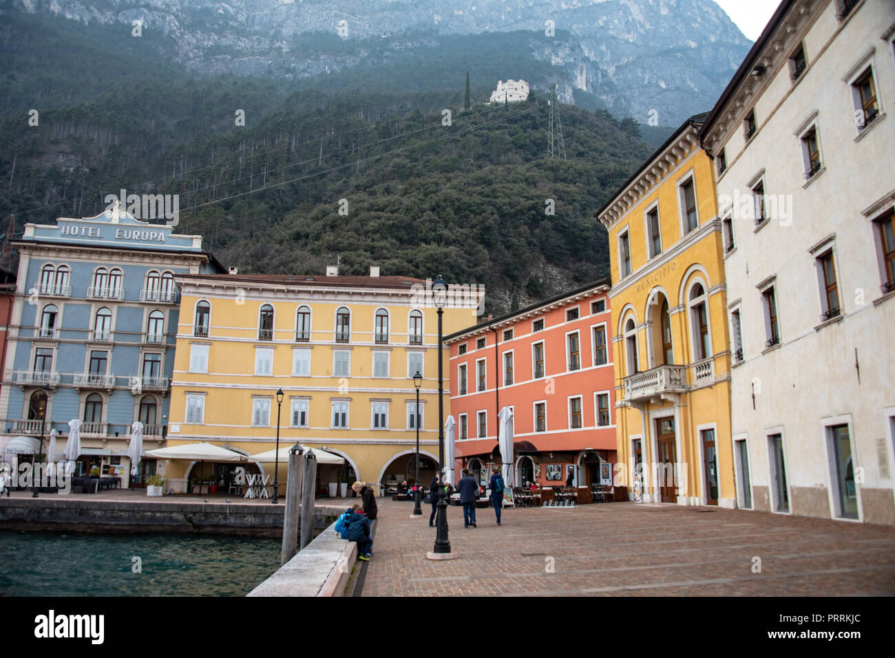 Farbenfrohe Gebäude und die Kapelle von Santa Barbara in der Ferne, Riva del Garda, Gardasee, Italien Stockfoto