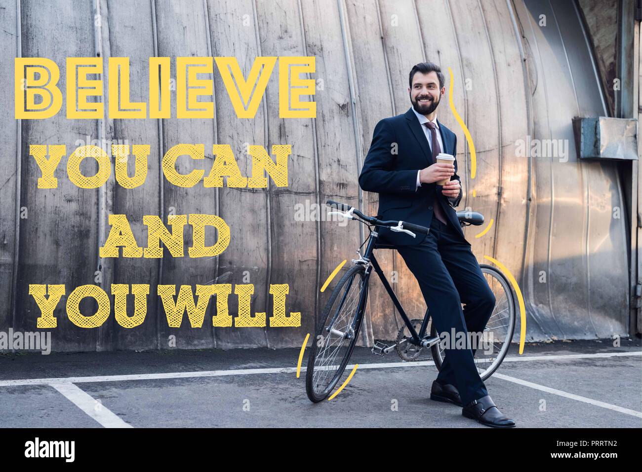 Lächelnd Geschäftsmann mit Einweg Tasse Kaffee lehnte sich auf dem Fahrrad auf der Straße mit Glauben, Sie können und Sie werden Stockfoto