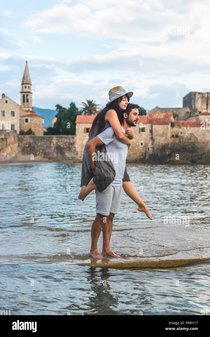 Freund huckepack mit Freundin auf Ricardova Glava Strand in Budva, Montenegro Stockfoto