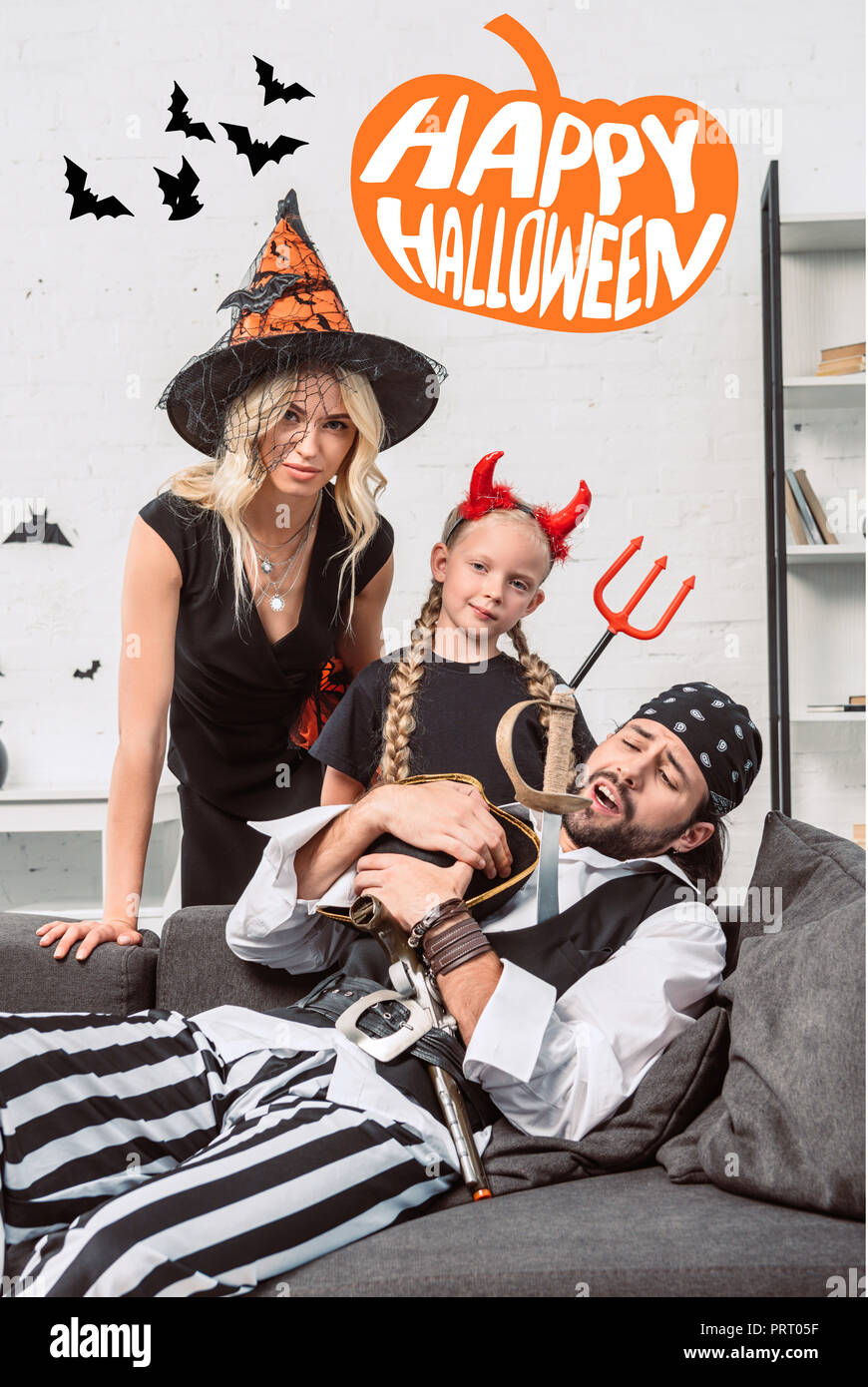 Porträt der Familie in Halloween Kostüme zu Hause mit "Happy Halloween" Schriftzug Stockfoto