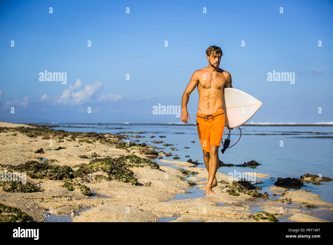 Die jungen Sportler mit Surfen Board zu Fuß am Sandstrand Stockfoto