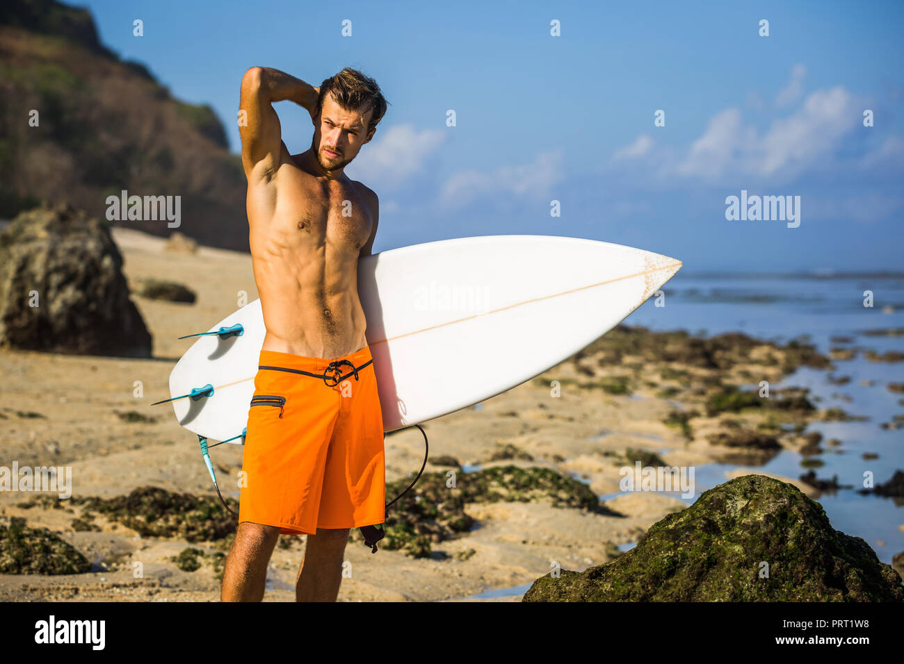Junge Surfer mit Surfen board stehend auf Sandstrand in der Nähe von Ocean Stockfoto