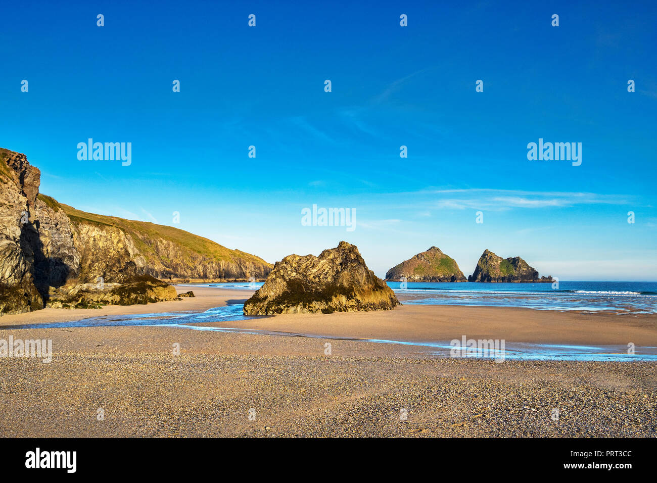 Felsen auf Holywell Strand, mit einem Blick durch Der off shore Carters Felsen, Cornwall, Großbritannien Stockfoto