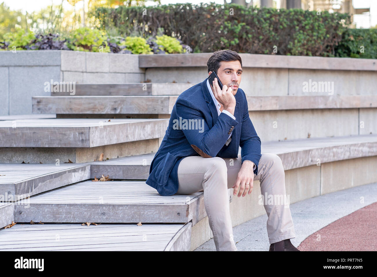 Attraktive, moderne Geschäftsmann reden und SMS auf sein Telefon. Erfolgreiche Unternehmer arbeiten. Stockfoto