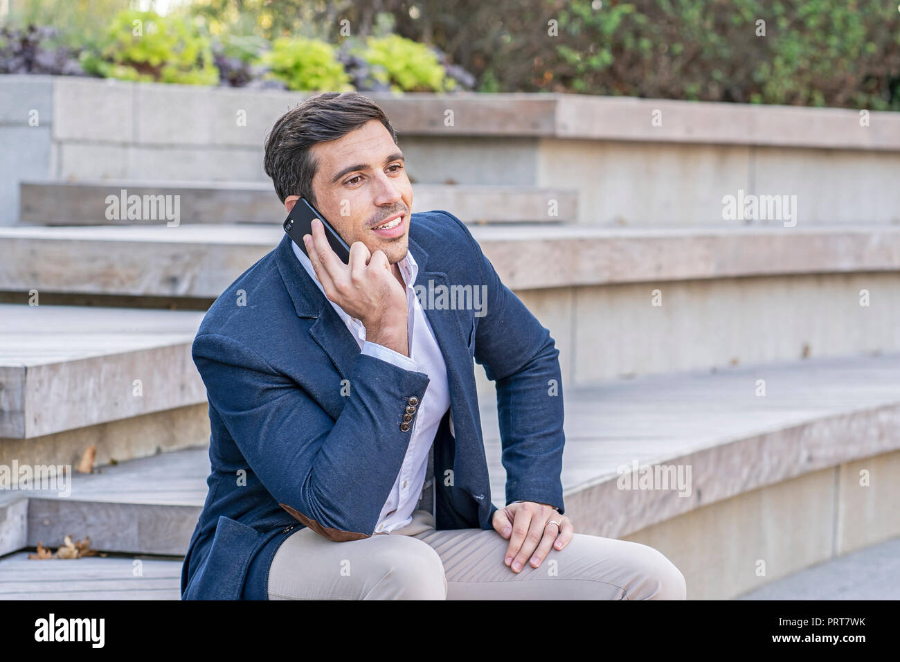 Attraktive, moderne Geschäftsmann reden und SMS auf sein Telefon. Erfolgreiche Unternehmer arbeiten. Stockfoto