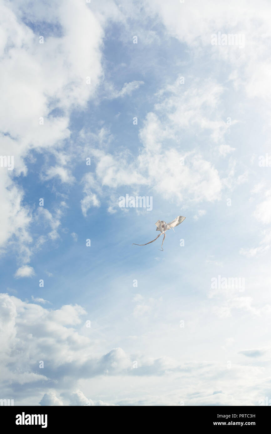 Weißen Drachen gegen den blauen Himmel voller Wolken. Vertikales Bild Stockfoto