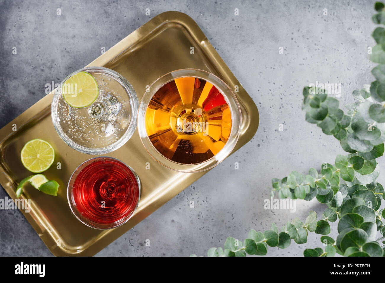 Drei alkoholische Cocktails in einer Brille auf einem goldenen Tablett das Konzept einer Partei und an den Feiertagen. Ansicht von oben. Stockfoto