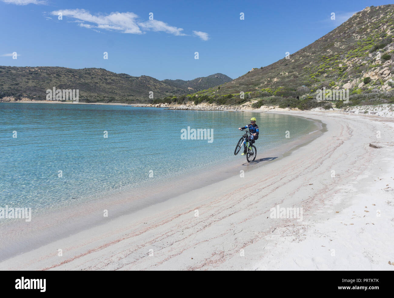 Radfahrer tun Wheelie am Strand, Villasimius, Sardinien, Italien Stockfoto