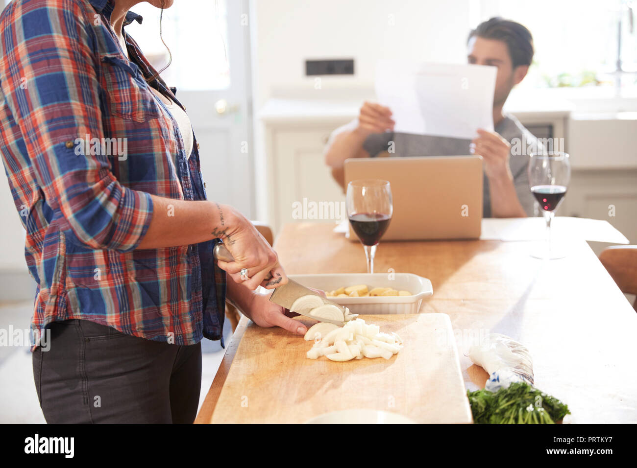 Frau Vorbereitung Gemüse am Küchentisch, Freund lesen Schreibarbeiten Stockfoto