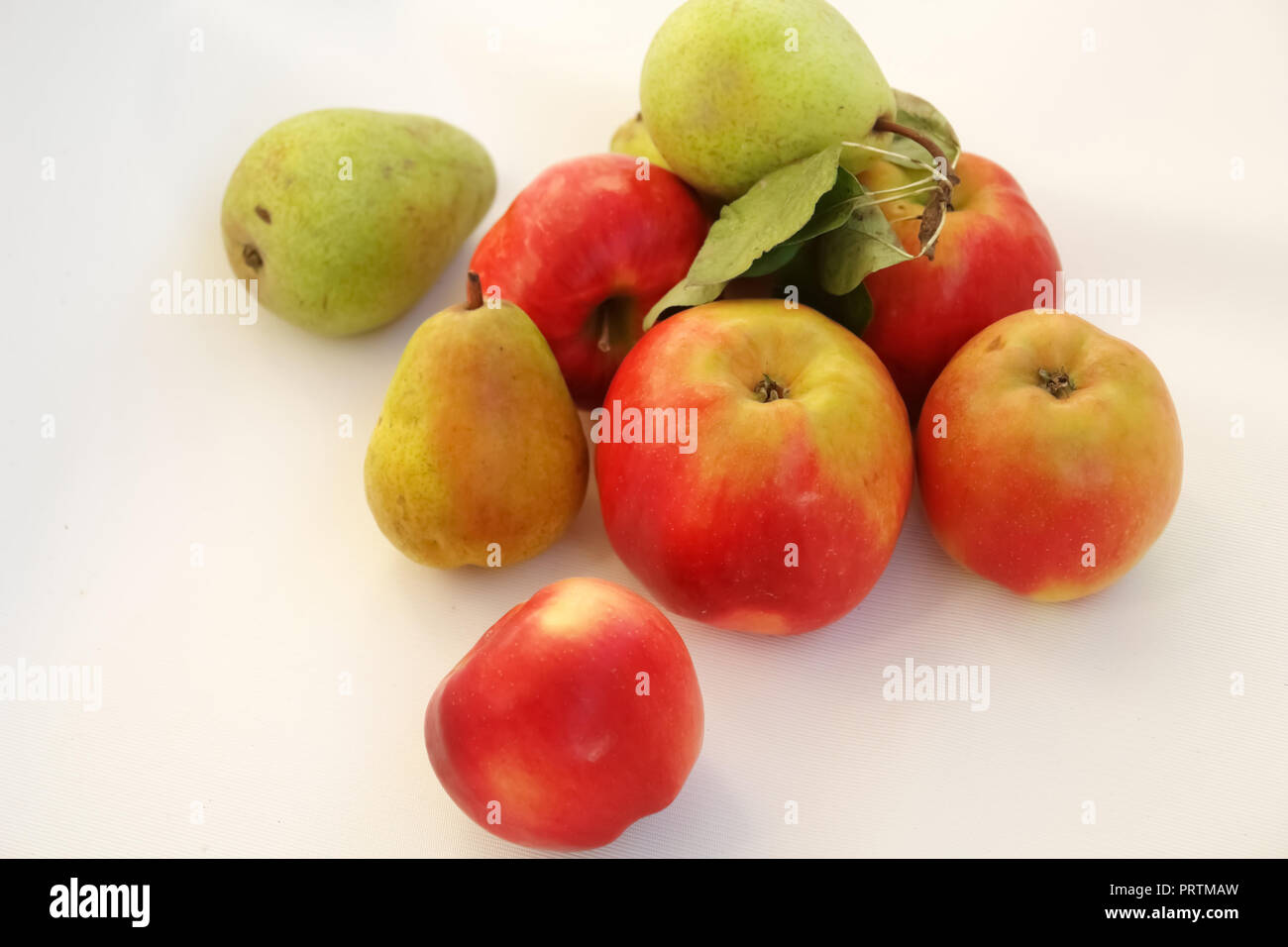 Rote Äpfel und Birnen auf weißem Hintergrund. Stockfoto