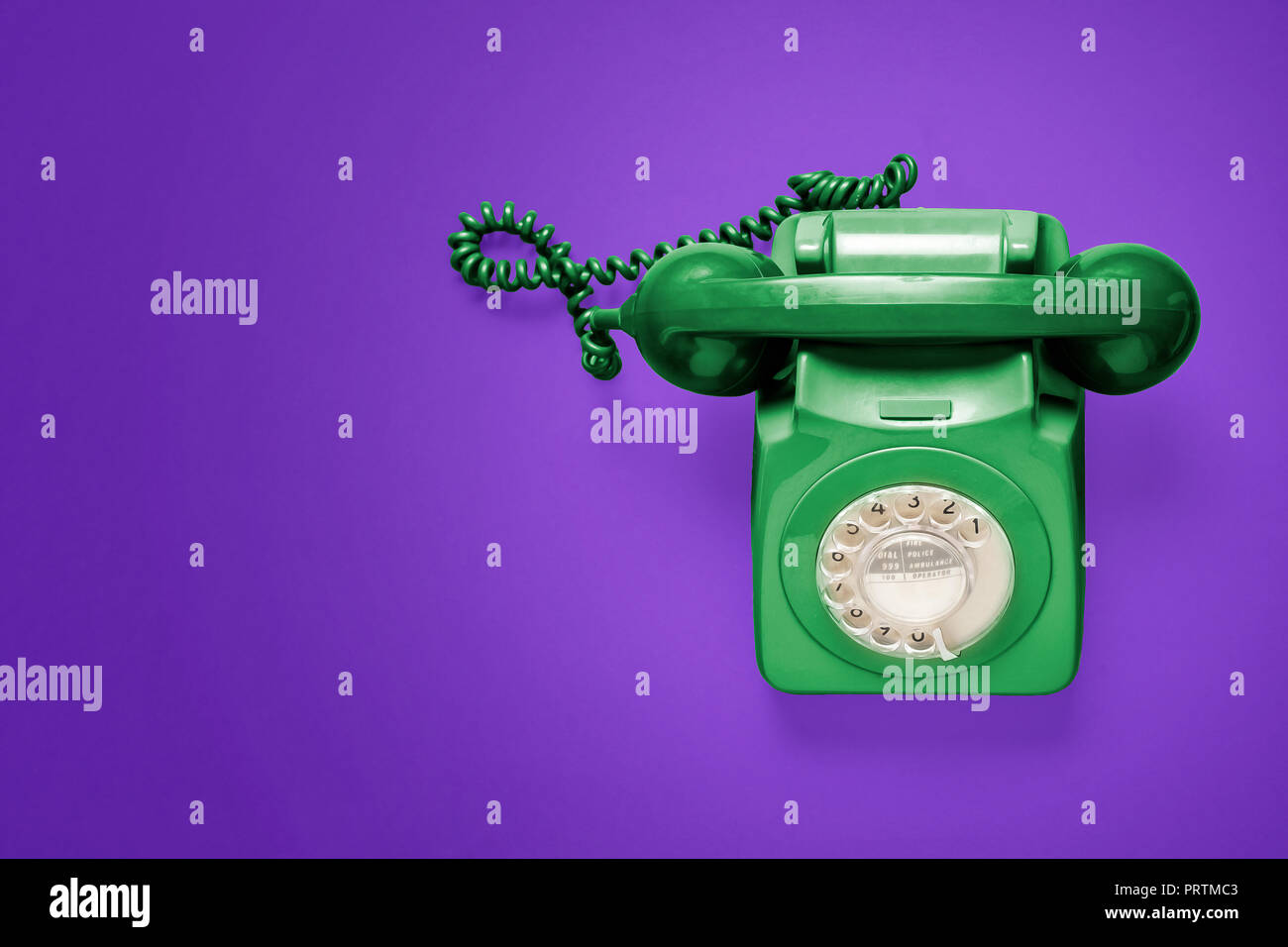 Grüne rotary Phone von oben auf einem violetten Hintergrund Stockfoto