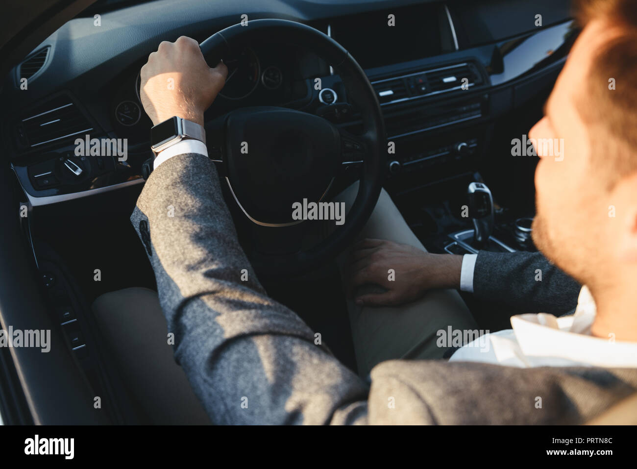Blick von oben auf ein Geschäftsmann in Anzug mit seinem Auto fährt Stockfoto