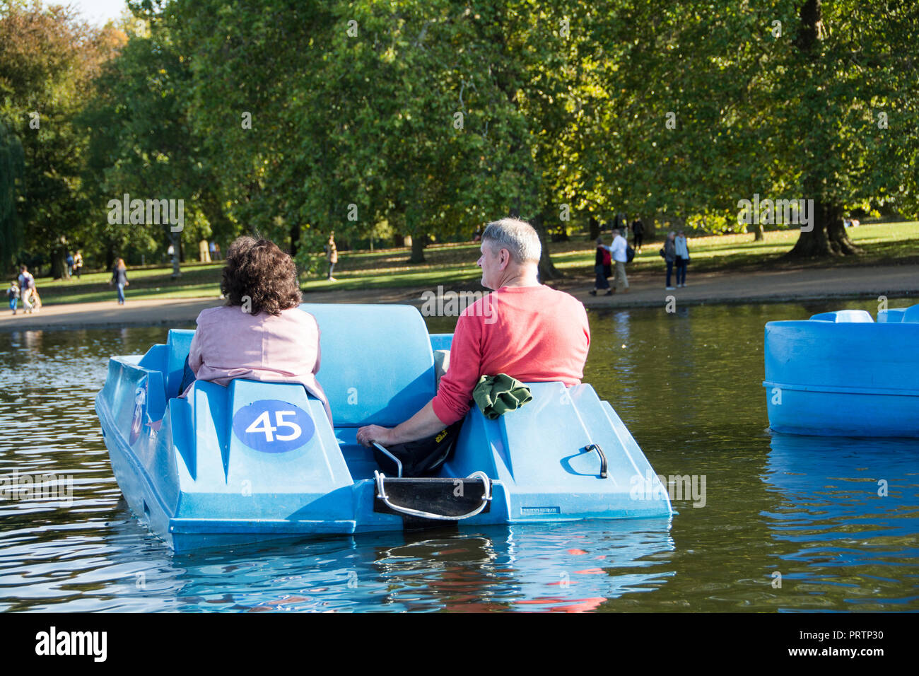 Ein Ehemann und eine Ehefrau mit dem Tretboot auf dem Serpentine im Londoner Hyde Park, London, UK Stockfoto