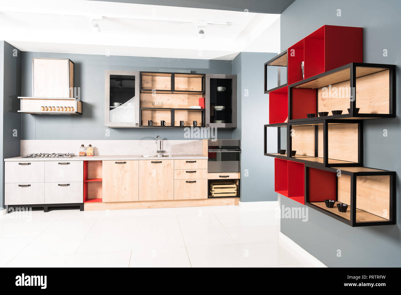 Innenraum der moderne saubere helle Küche mit Möbel und Holz- rote Regale Stockfoto