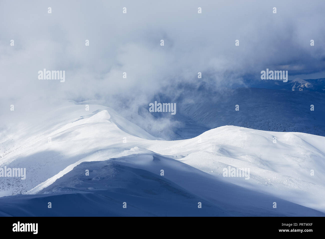 Winter in den Bergen. Sonnige frostigen Tag. Ridge in Wolken und Nebel Stockfoto