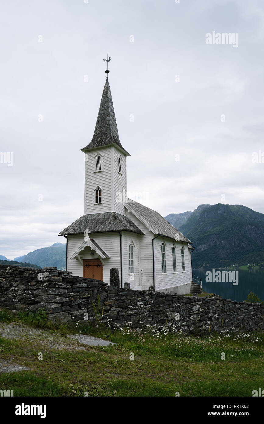 Norwegische Kirche in Lustre Kommune. Nes kyrkje. Old Stone Zaun. Bedeckt nördlichen Wetter Stockfoto