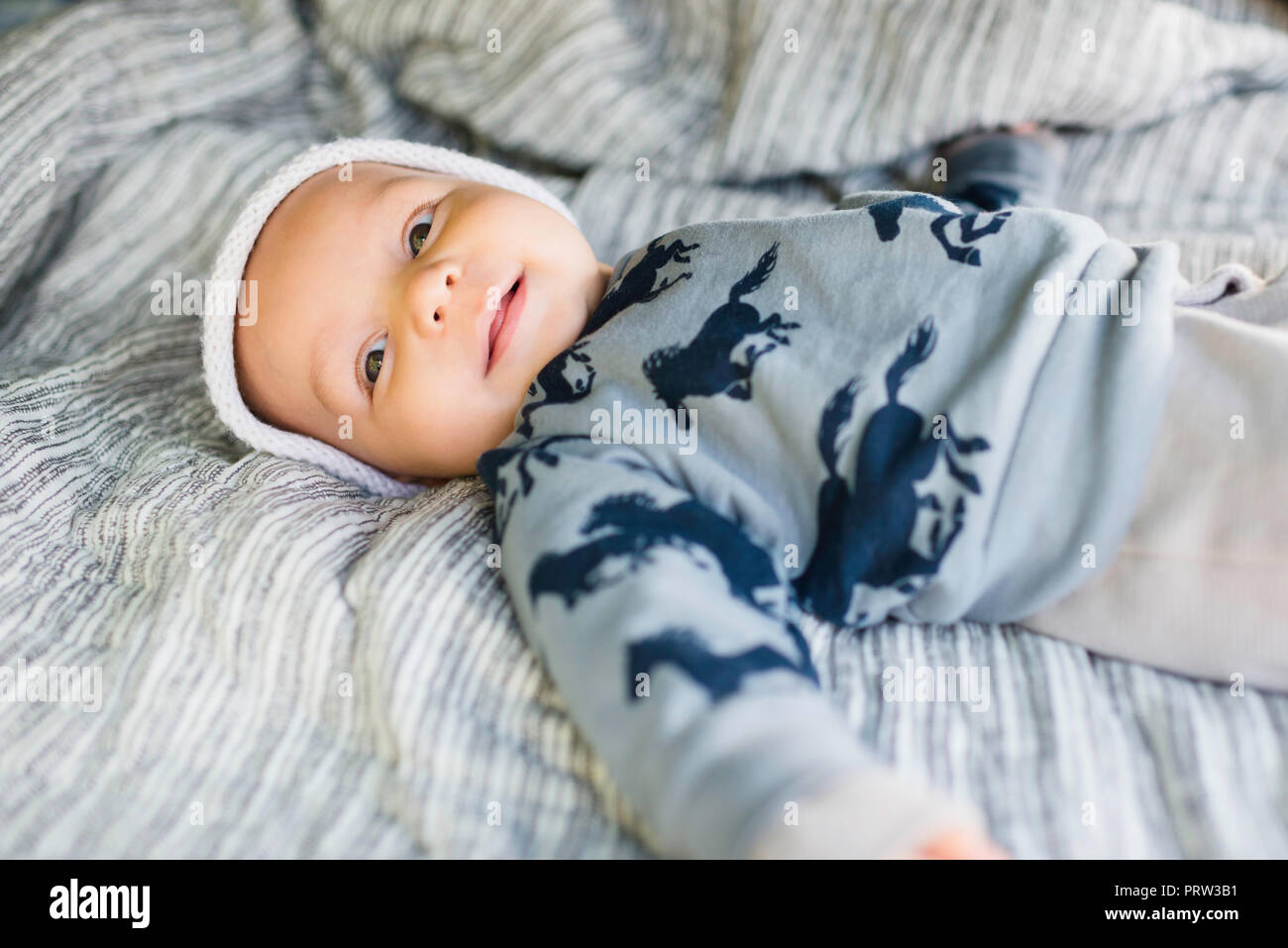 Smiling baby boy liegend auf Bett Stockfoto