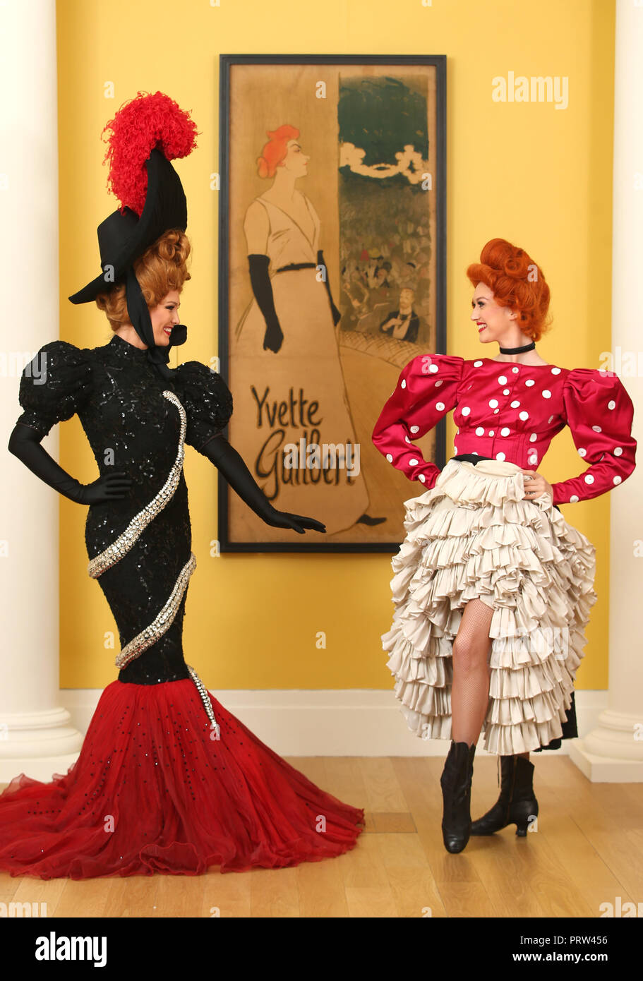 Mathilde Tutiaux (links) und Lucy Monaghan, can-can Tänzer aus dem Moulin Rouge in Paris, führen neben einer Lithographie Plakat für Yvette Guilbert (1894) Bei der Eröffnung der neuen Ausstellung "pin-ups: Toulouse-Lautrec und die Kunst der Berühmtheit' an der Royal Scottish Academy in Edinburgh. Stockfoto