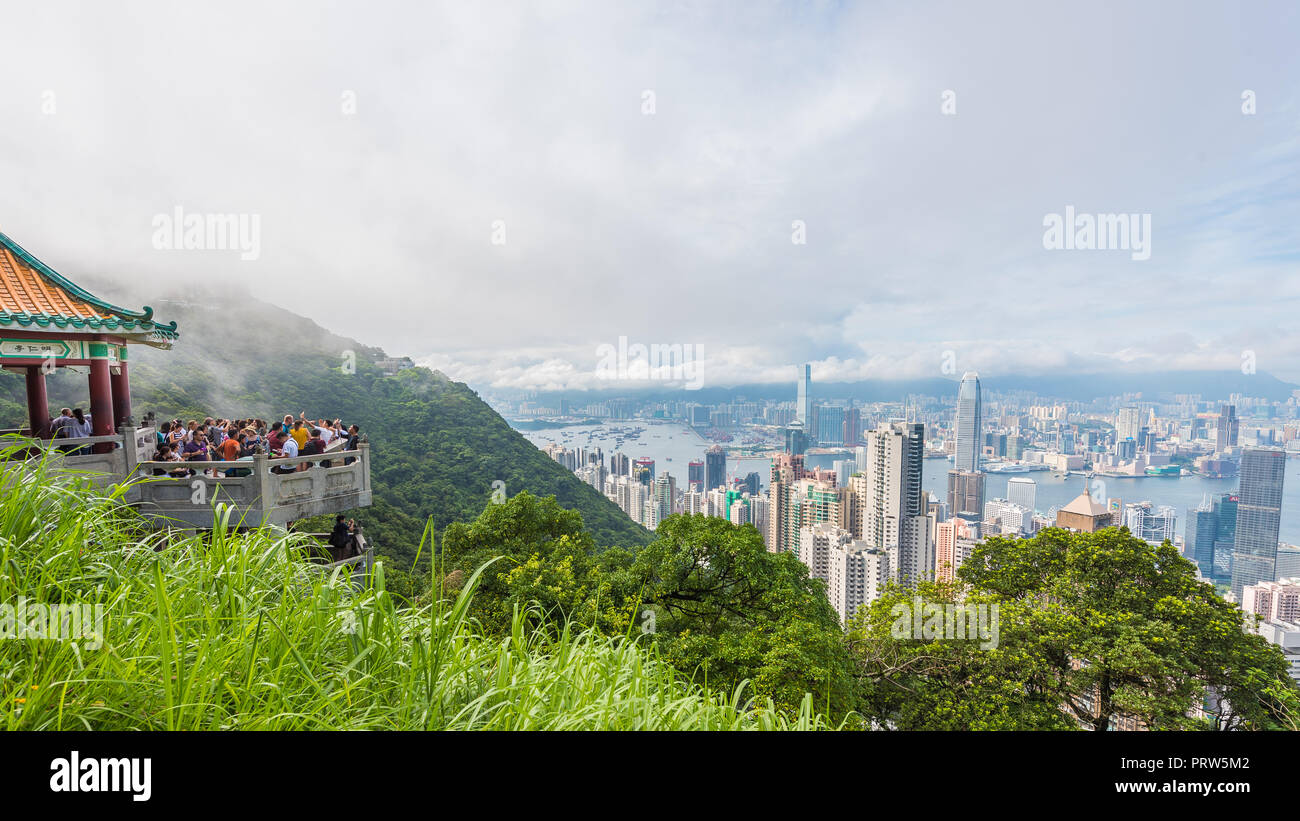 VICTORIA PEAK, HONG KONG - 4. AUGUST 2017: Blick vom Victoria Peak auf dem Weg zu Victoria Hafen mit den Touristen am Aussichtspunkt Balkon Stockfoto