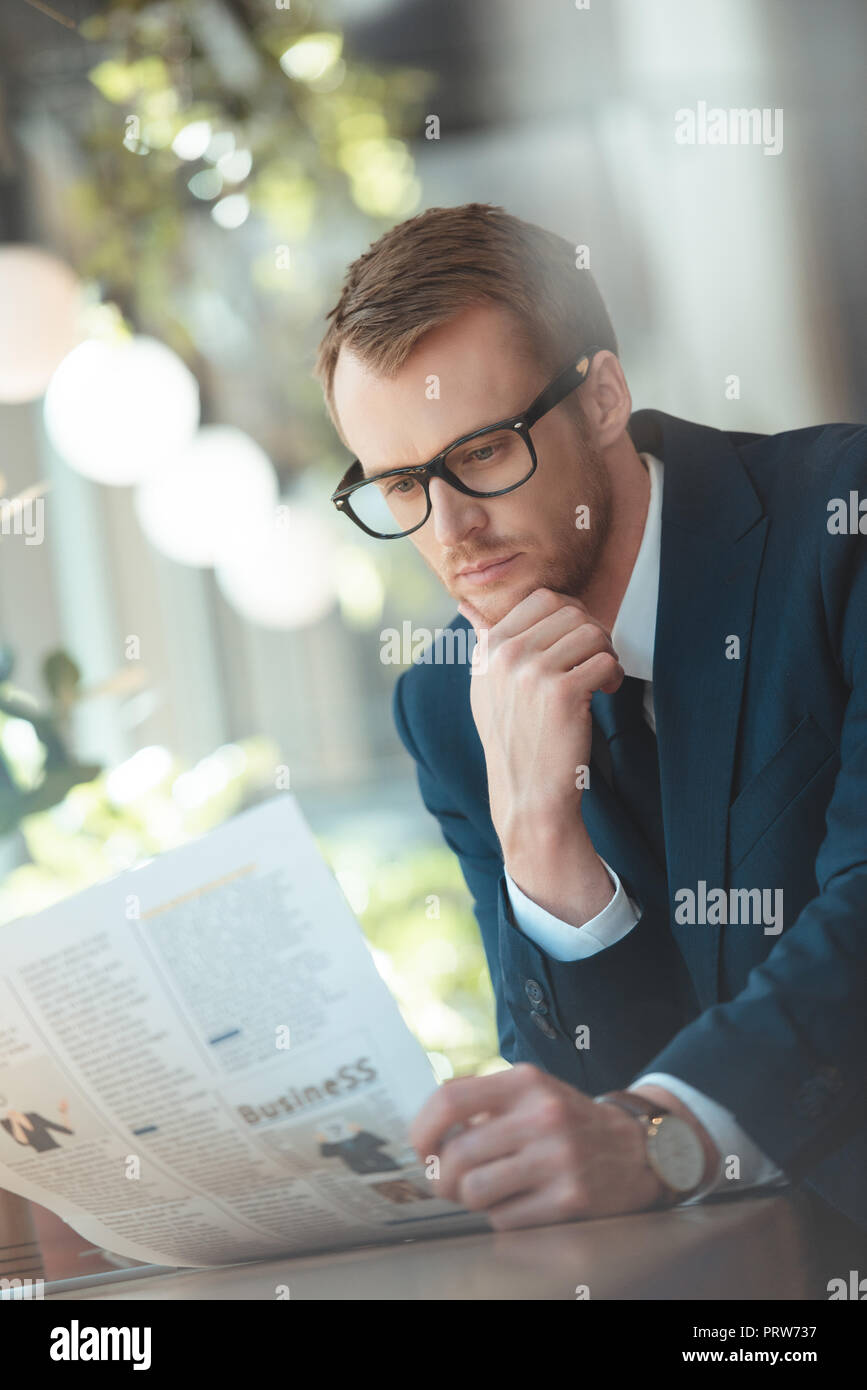 Portrait von Geschäftsmann in Brillen lesen Zeitung im Cafe Stockfoto