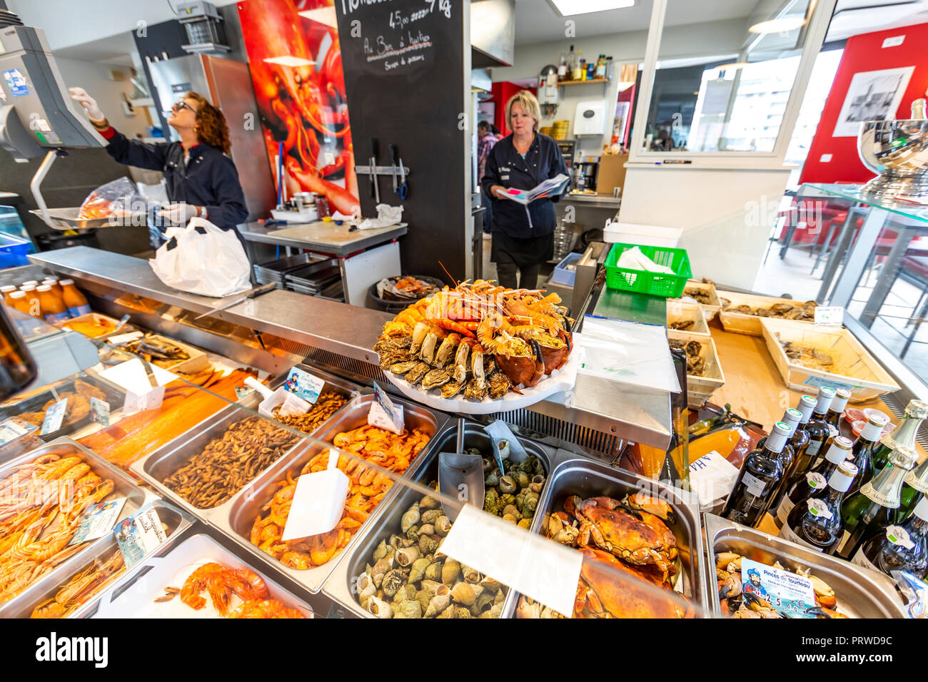 Die Mitarbeiter an der La Halle Fischhändler und Restaurant, bereiten Sie eine fruits de Mer weg Platter. Dünkirchen, Frankreich Stockfoto