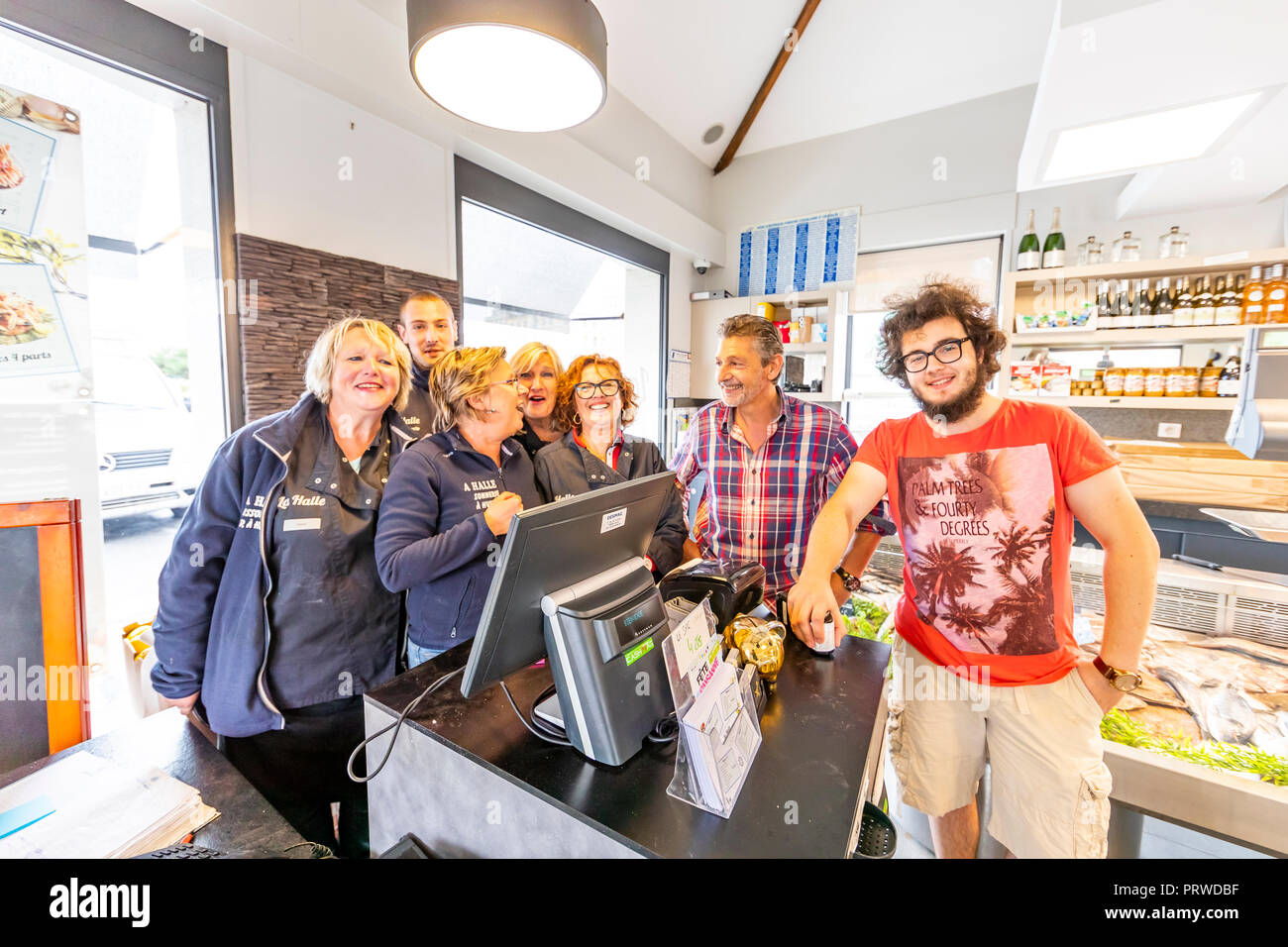 Das Team von La Halle Fischhändler und Restaurant, posieren für informelle Gruppe Foto in den Räumlichkeiten. Dünkirchen, Frankreich Stockfoto