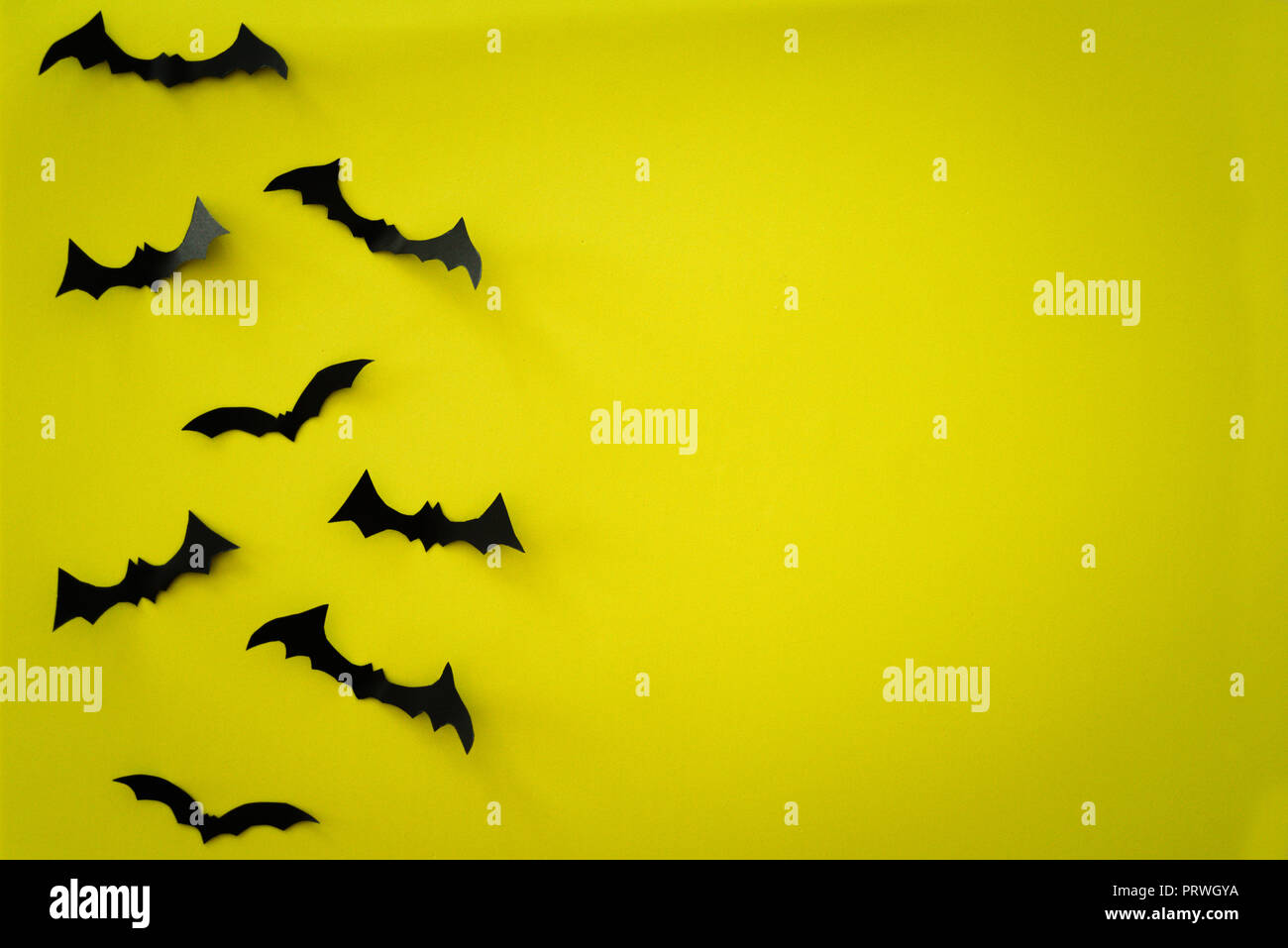 Flying schwarzes Papier Fledermäusen auf gelben Hintergrund. Halloween. Text Raum Stockfoto