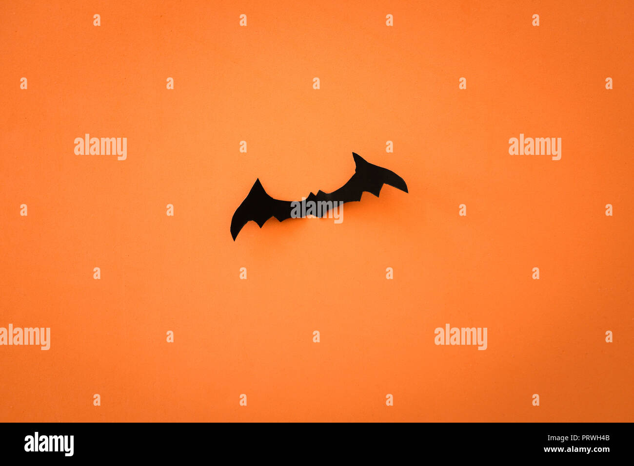 Flying schwarzes Papier Fledermäusen auf orangem Hintergrund. Halloween. Text Raum Stockfoto