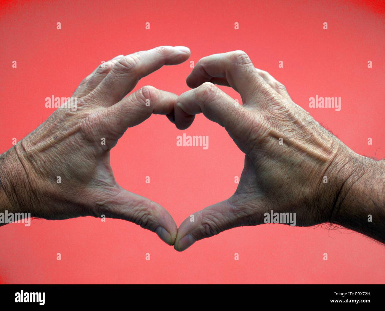 Rotes Herz Form von Mans Händen gemacht Stockfoto