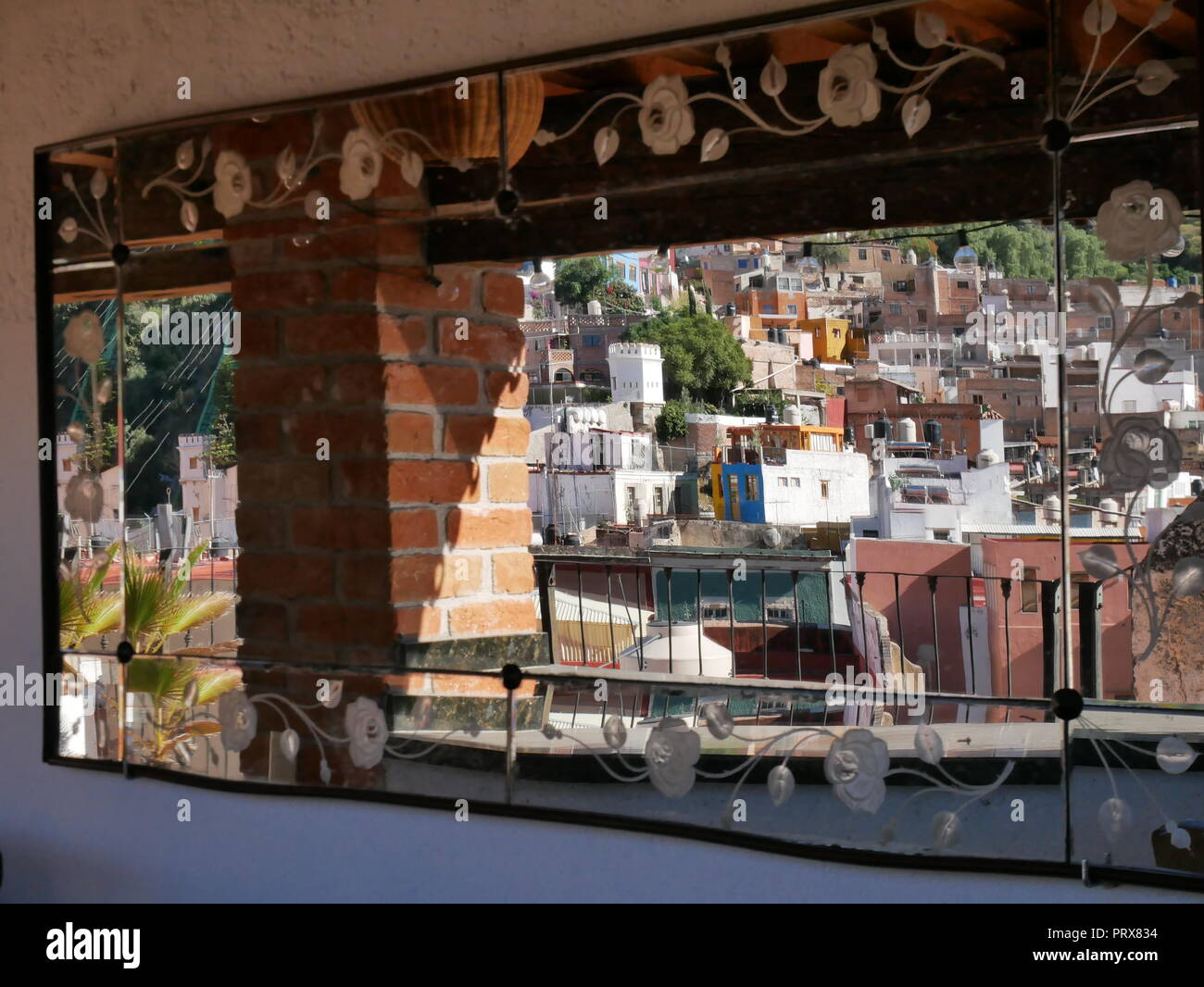 Traditionelle bunte Häuser auf einem Hügel in der Stadt Guanajuato, der Reflexion in einem Spiegel auf einer Dachterrasse, Mexiko Stockfoto