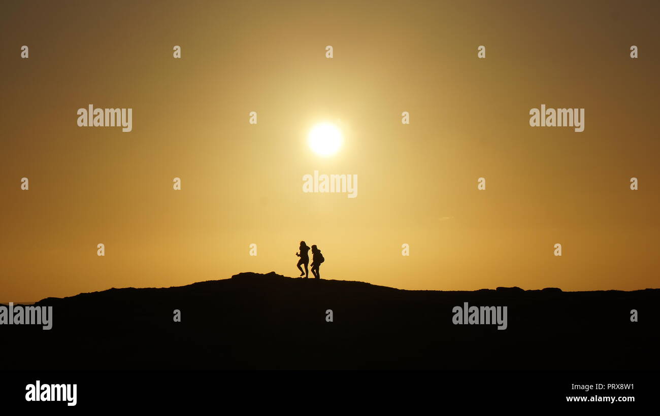 Die Silhouette eines jungen Paares in einem Hang Stockfoto
