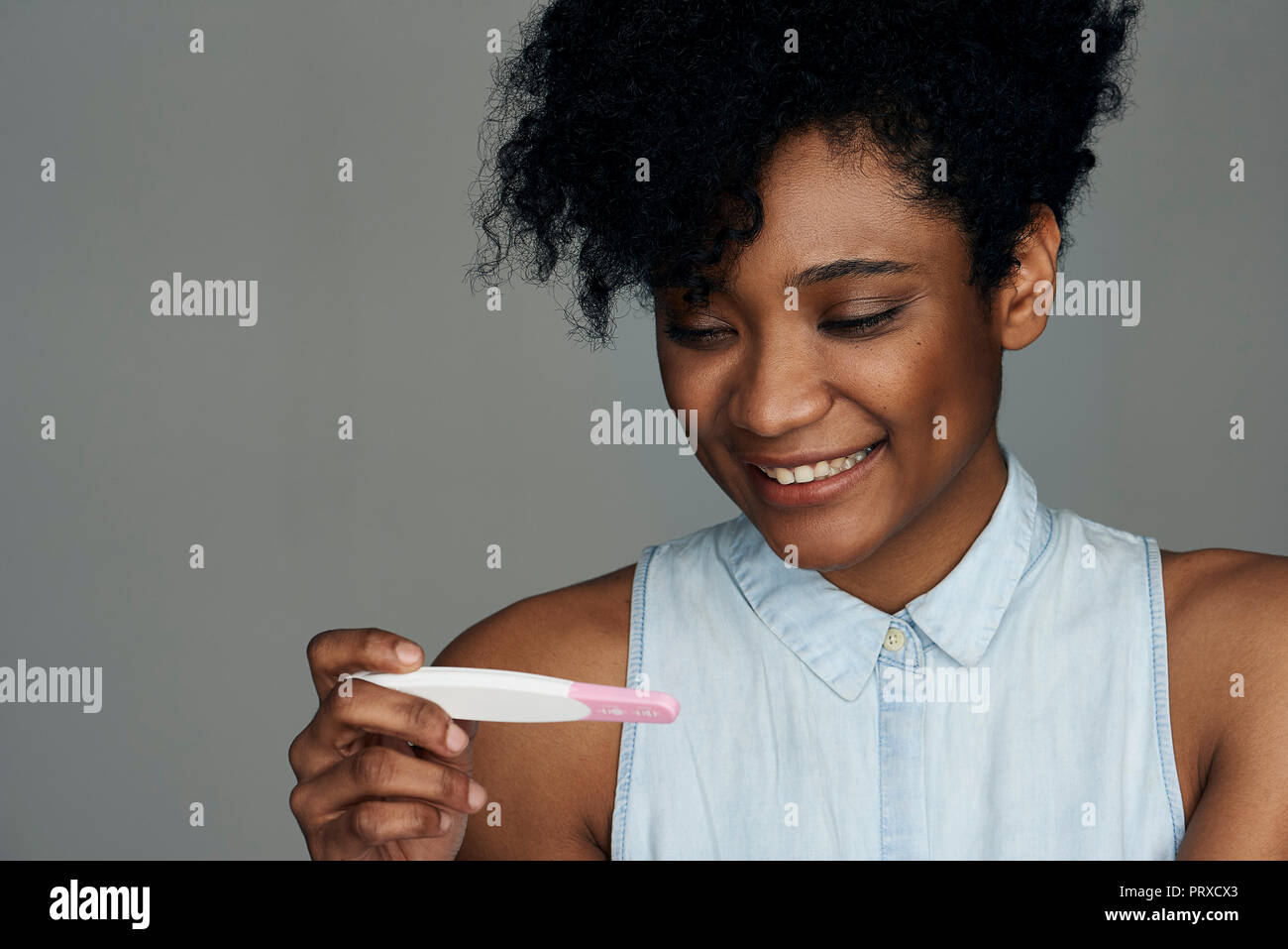 Nahaufnahme der jungen Frau an der Schwangerschaft Teststreifen suchen Stockfoto