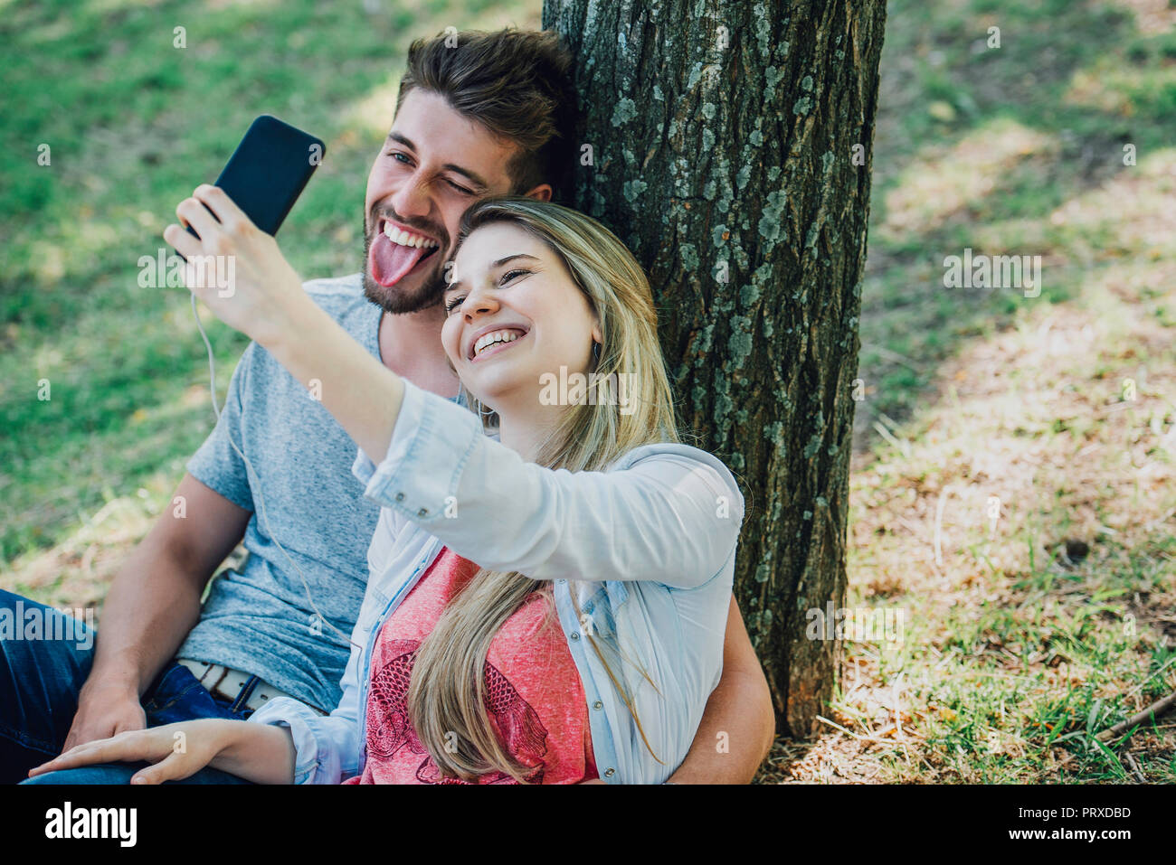 Junges Paar Musik hören und dabei mit einem Smartphone selfie Stockfoto