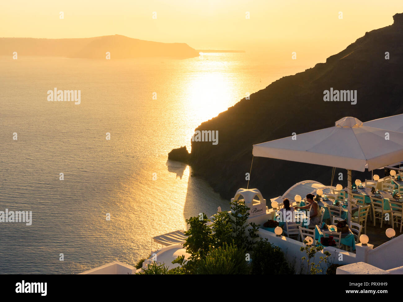 Restaurant mit Blick auf die Caldera von Santorin bei Sonnenuntergang von den Klippen gelegene Dorf Imerovigli, Santorini, Kykladen, Griechenland Stockfoto