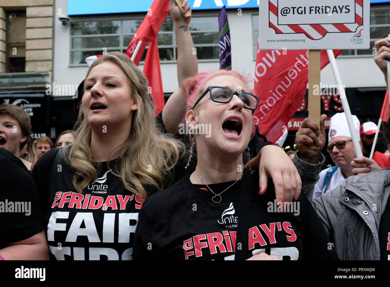 Zwei Frauen gesehen mit schwarzen T-Shirts mit dem TGI Fridays logo bittet um faire Tipps am Arbeitsplatz während der Demonstration. Wetherspoons, TGI Fridays, und McDonald's Arbeiter Kundgebung zusammen in London, bessere Arbeitsbedingungen und eine angemessene Bezahlung in der Hotellerie zu verlangen. Stockfoto