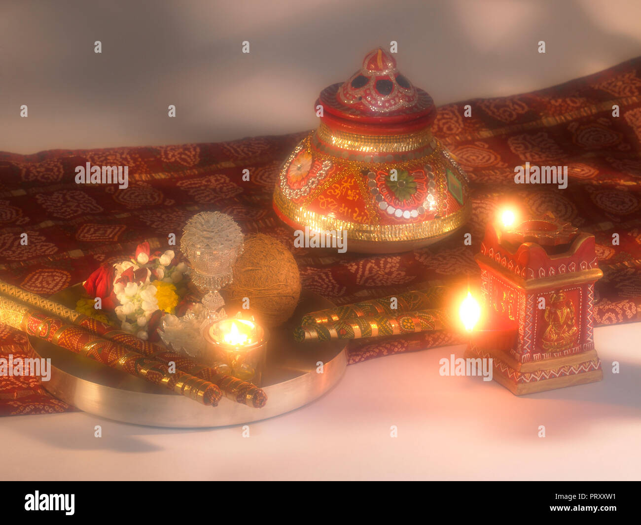 Ein Stilleben von DASSERA FESTIVAL OBJEKTE IN MUMBAI INDIEN ZEIGEN EINE KALASH/POT, DIYAS, Süßigkeiten, BANDHANI, SAREE, SILBER THALI mit Kokosnuss, DIYA, Blume Stockfoto