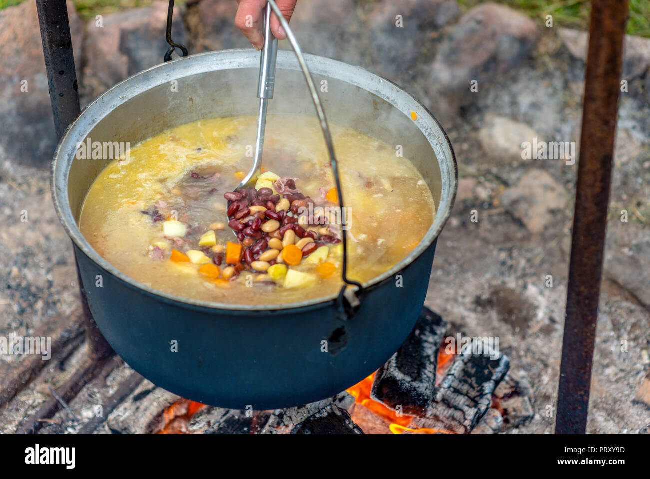 Kochen in einem Topf am Lagerfeuer. Sommer Camping Konzept. Stockfoto