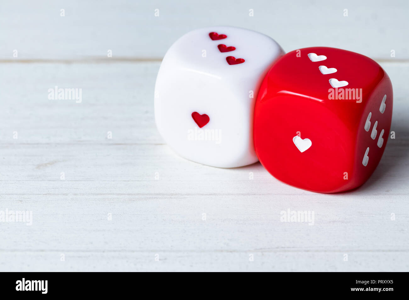 Zwei rote und weiße Valentinstag Herz Würfel auf Holz- Hintergrund.  Kopieren Sie Speicherplatz auf dem links unten Stockfotografie - Alamy