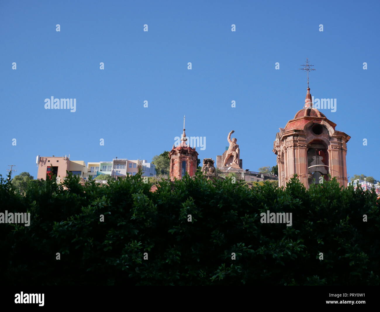 Skyline der Stadt Guanajuato vom Union Garten eingenommen, die den Pipila Statue, mit park Bäume im Vordergrund, Mexiko Stockfoto