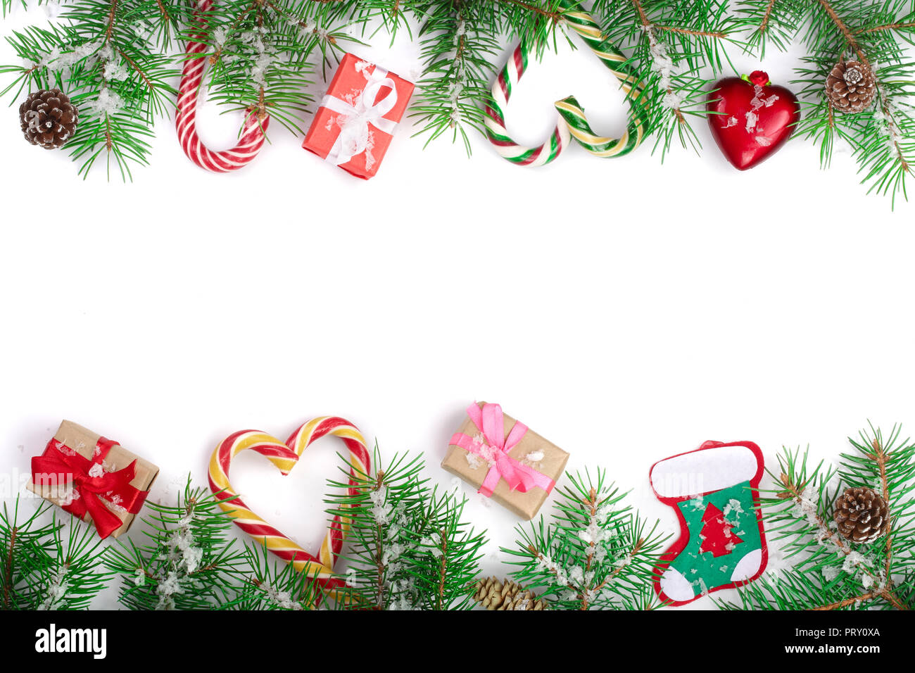 Weihnachten Rahmen der Fir Tree Branch mit Zuckerstangen und Boxen auf weißem Hintergrund mit Kopie Platz für Ihren Text isoliert. Ansicht von oben. Stockfoto