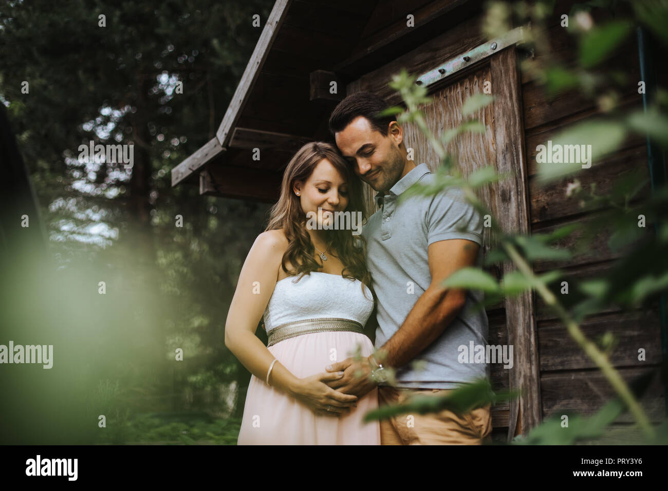 Schwangere Frau und ihr Ehemann teilen einige freudige Momente im Freien Stockfoto