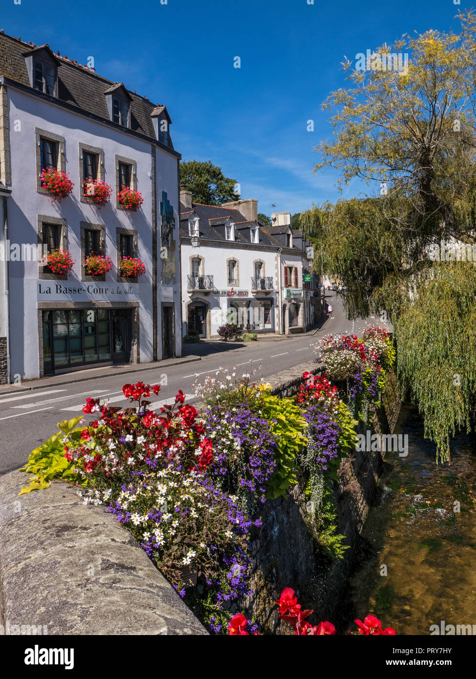 Blumen über die pont-aven Brücke und den Fluss Aven mit stilvollen Geschäften hinter Bretagne Frankreich Stockfoto